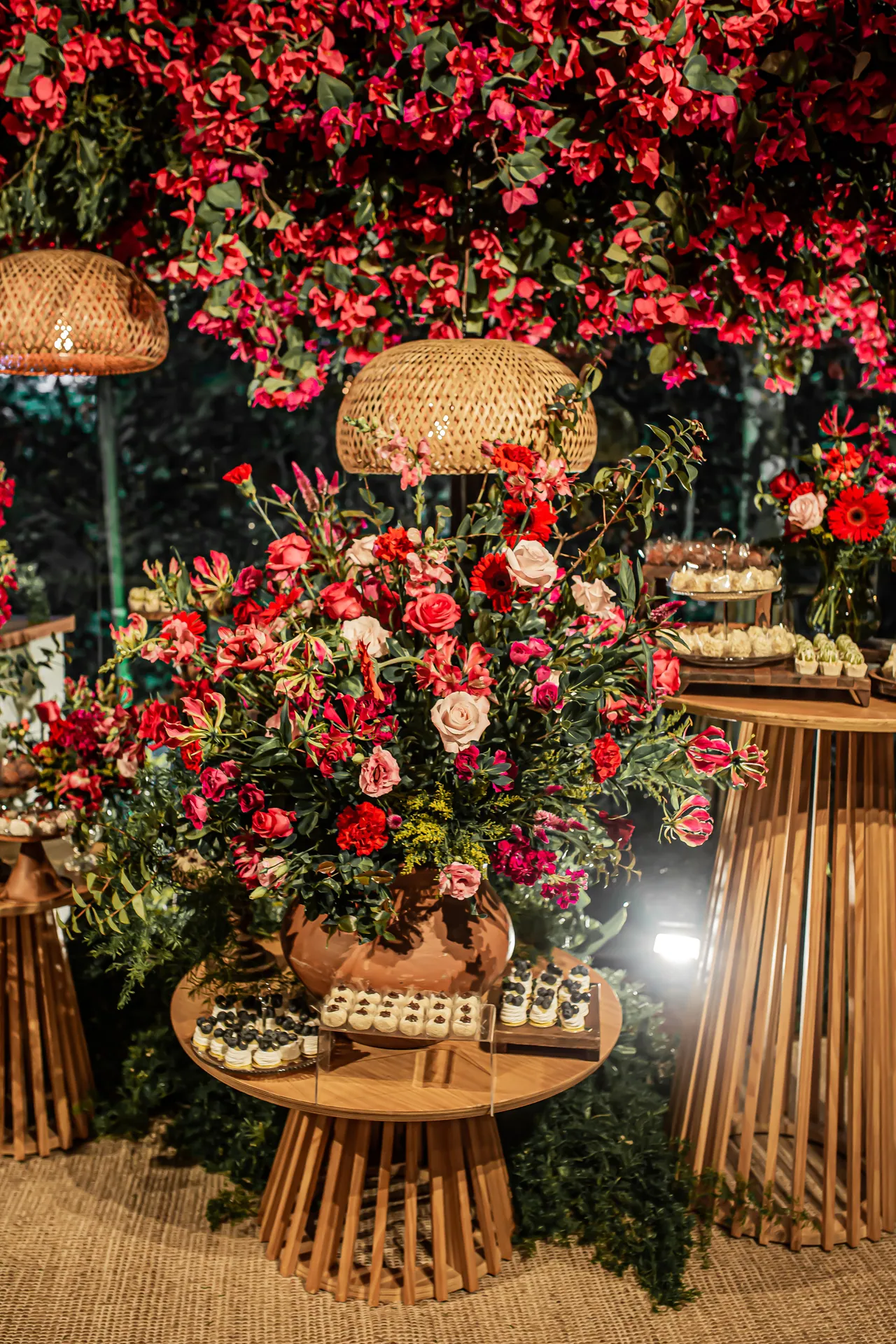 Decoração de formatura com flores vermelhas, bolo e painel luminoso.